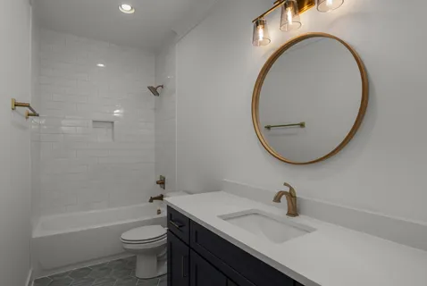 a bathroom with a sink a toilet and a mirror