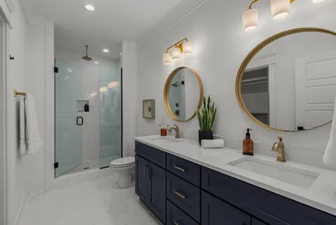 a bathroom with a double vanity sink mirror and shower