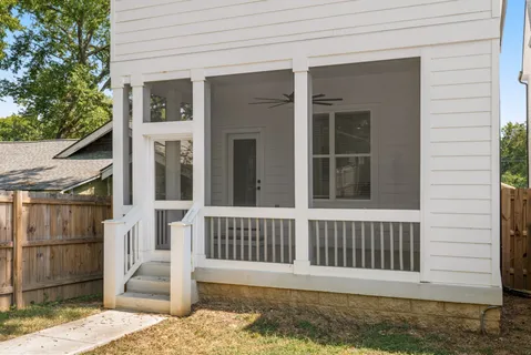 a view of a house with a small yard and wooden floor and fence