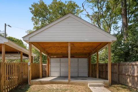 a view of a wooden house with a small yard and wooden fence