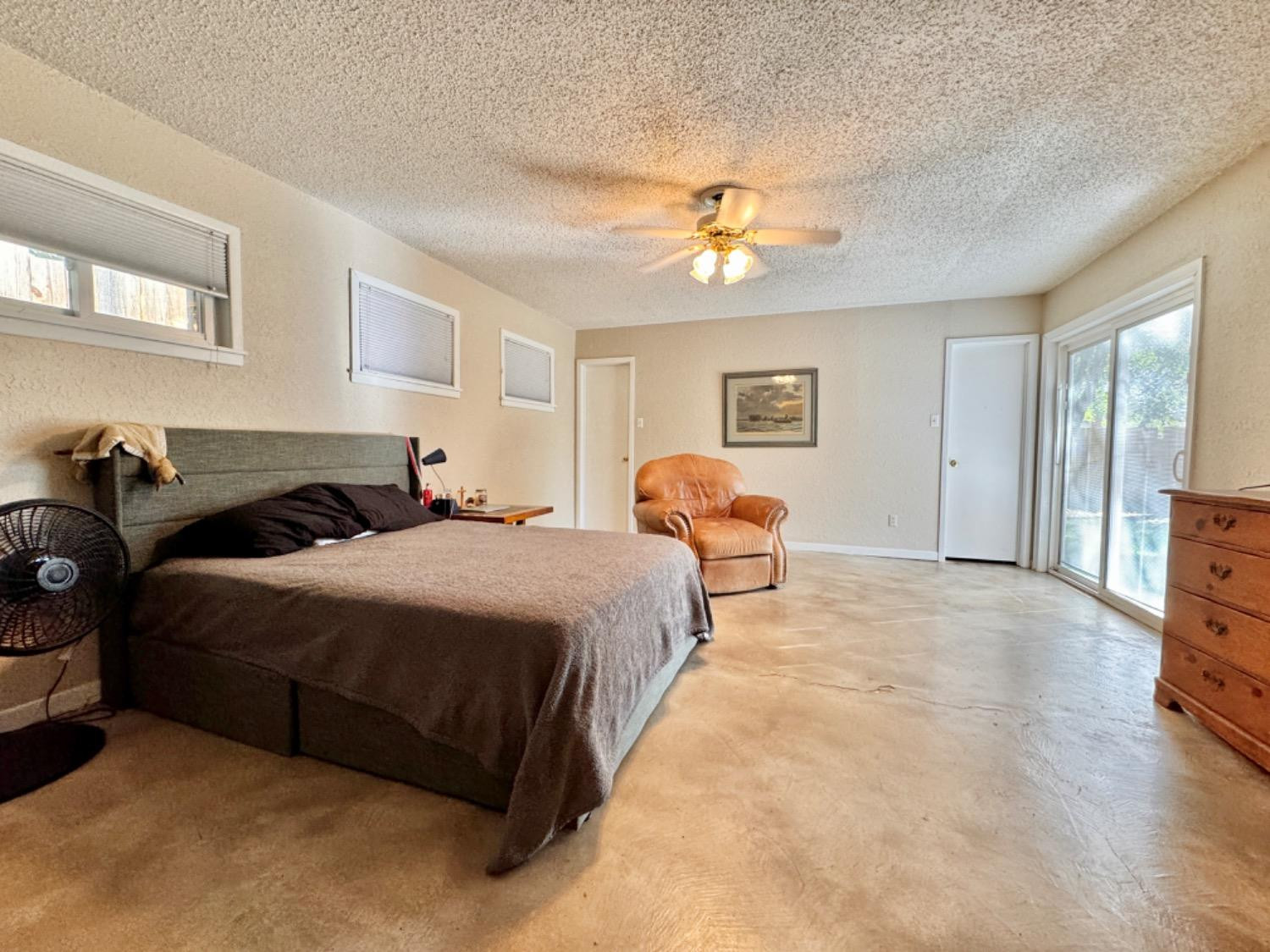 2621 23rd Street Lubbock, TX 79410 - Photo 12 of 38 a spacious bedroom with a bed a window and a chandelier