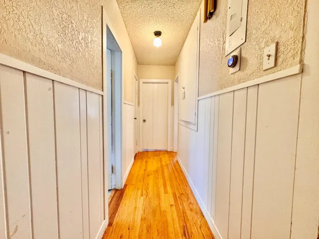 a large bedroom with a bed and wooden floor