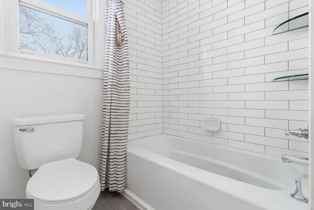 a white toilet sitting next to a bath tub