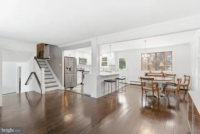 a living room with furniture wooden floor and floor to ceiling windows