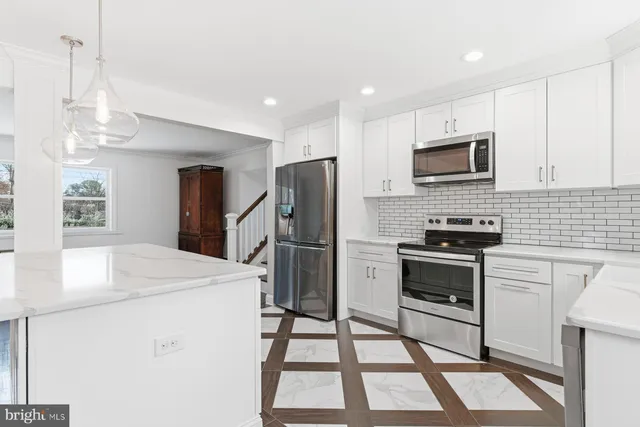 a kitchen with a sink a microwave a refrigerator and cabinets