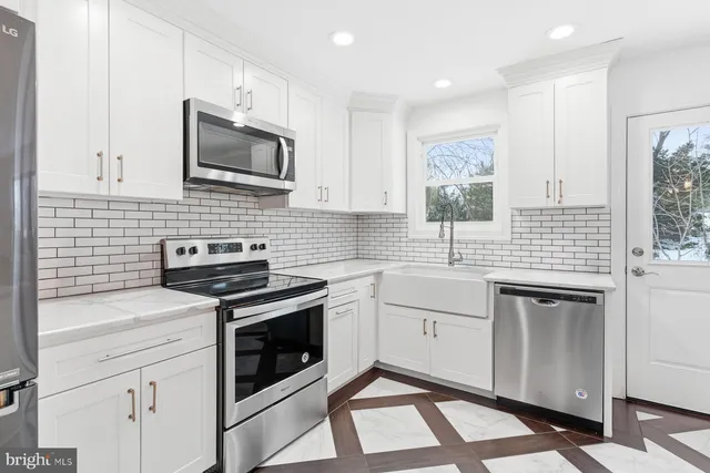 a kitchen with white cabinets stainless steel appliances and sink