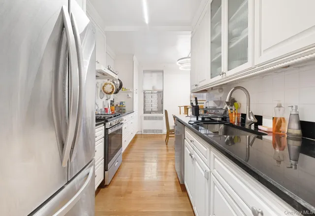 a kitchen with stainless steel appliances granite countertop a sink and a refrigerator