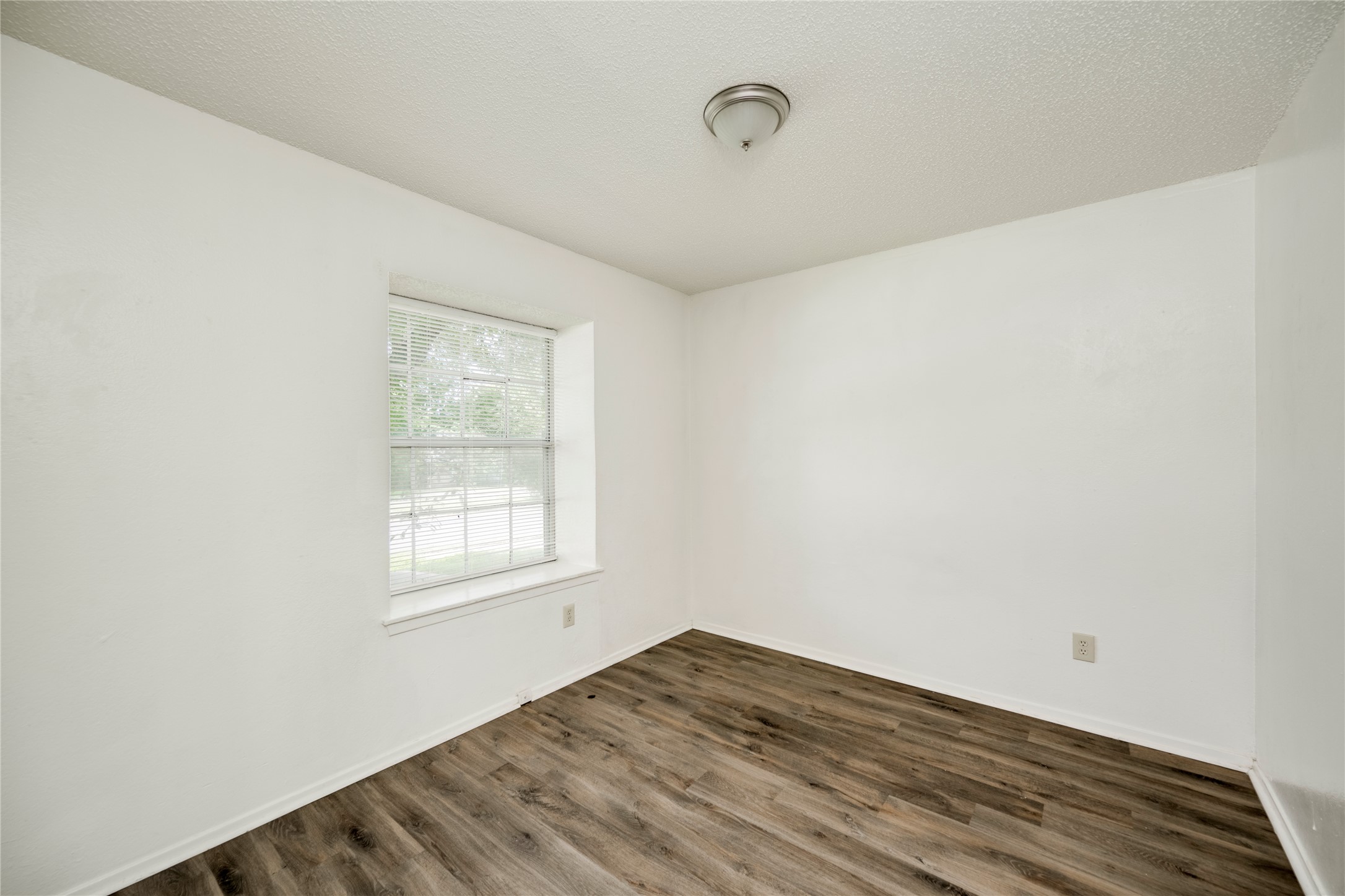 7918 West Gate Boulevard Austin, TX 78745 - Photo 6 of 31 Laminate flooring and a well-lit window create a serene atmosphere in this peaceful room.