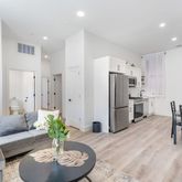 a living room with furniture and a dining table with kitchen view