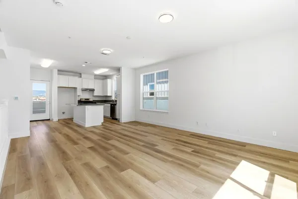 a view of kitchen with refrigerator stove and wooden floor