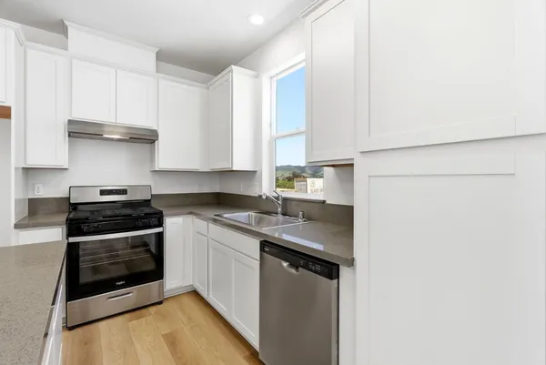 a kitchen with stainless steel appliances a stove a sink and a refrigerator