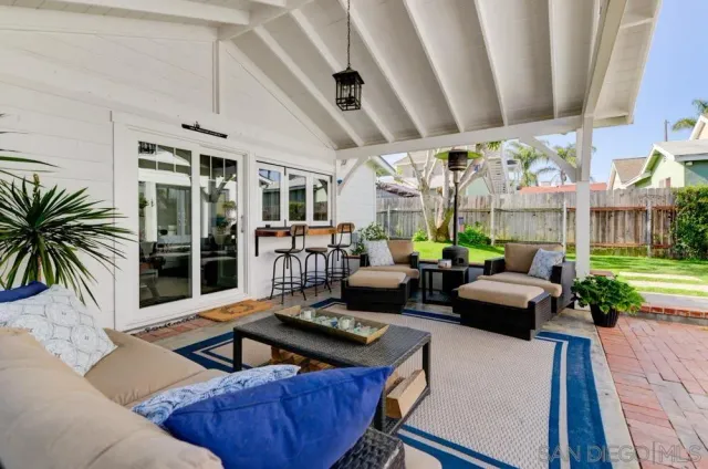 a living room with patio furniture and a large window