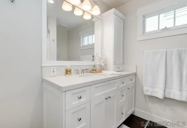 a bathroom with a sink a light fixture and a mirror
