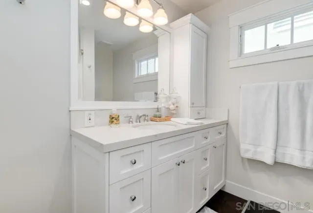 a bathroom with a sink a light fixture and a mirror