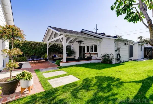a view of a patio with table and chairs potted plants and palm tree