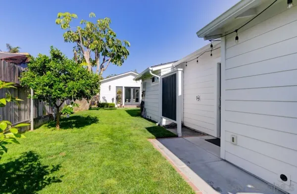 a view of backyard with potted plants and a bench