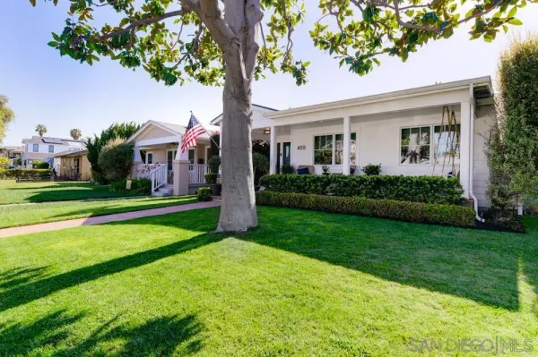 a front view of a house with a yard and potted plants