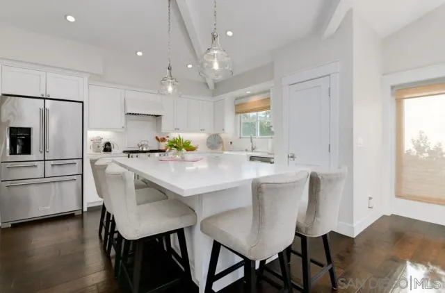 a kitchen with kitchen island a table and chairs in it