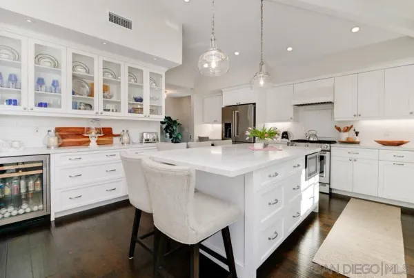 a kitchen that has cabinets a sink a stove and a wooden floor