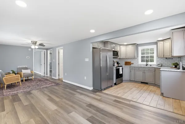 a kitchen with stainless steel appliances kitchen island granite countertop a refrigerator and cabinets