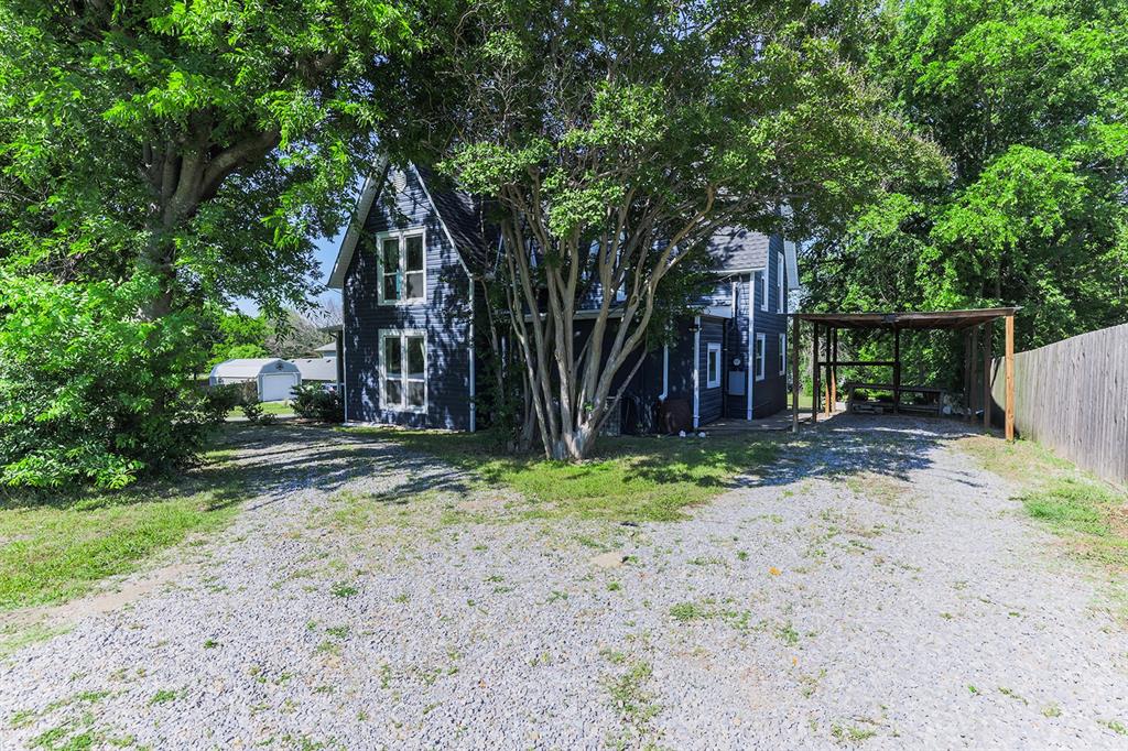 453 East Marshall Street Van Alstyne, TX 75495 - Photo 25 of 30 a backyard of a house with plants and large tree