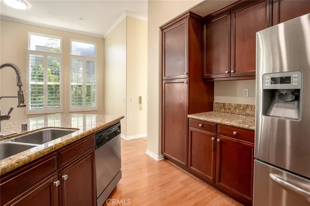 a kitchen with stainless steel appliances granite countertop a refrigerator and a sink