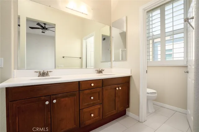 a bathroom with a double vanity sink a toilet and a mirror