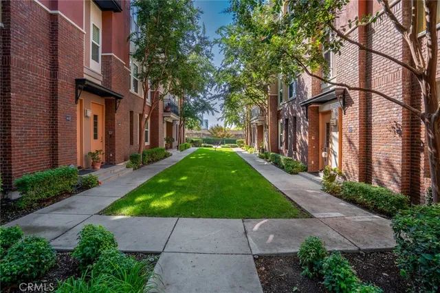 a view of a brick house with a yard and plants