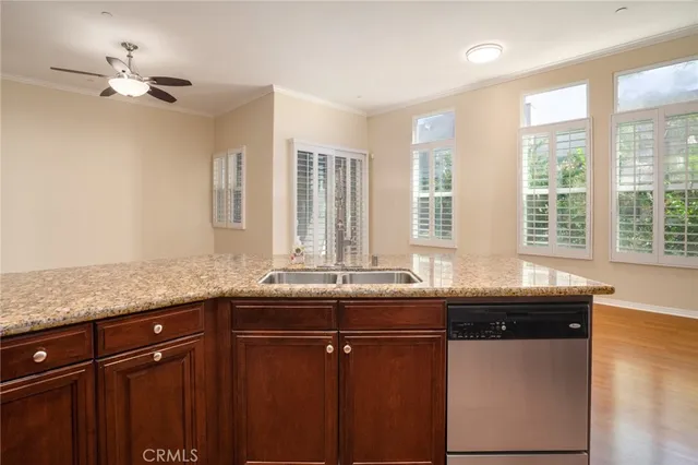 a kitchen with granite countertop a sink and dishwasher with wooden floor
