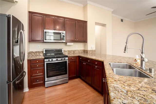 a kitchen with stainless steel appliances granite countertop a refrigerator stove and sink