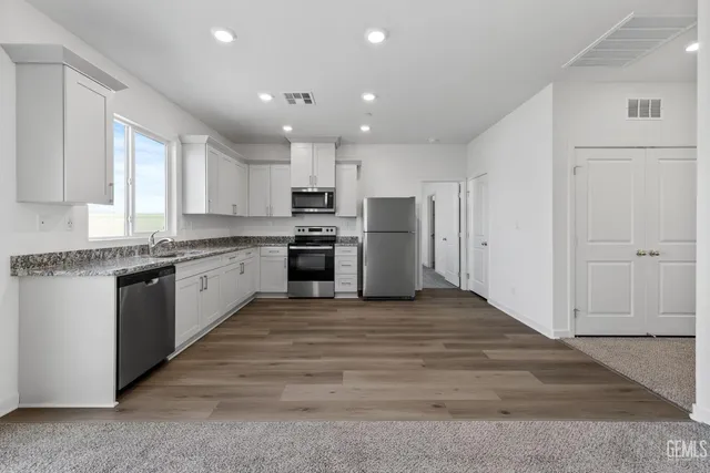 a large kitchen with cabinets and stainless steel appliances