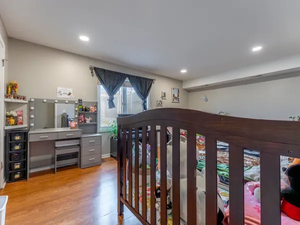 a bedroom with furniture wooden floor and window
