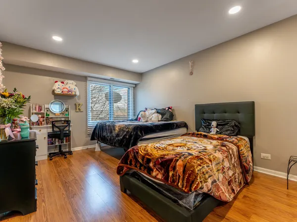 a bedroom with two beds and a desk