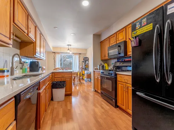 a kitchen with stainless steel appliances granite countertop a refrigerator a stove and a sink