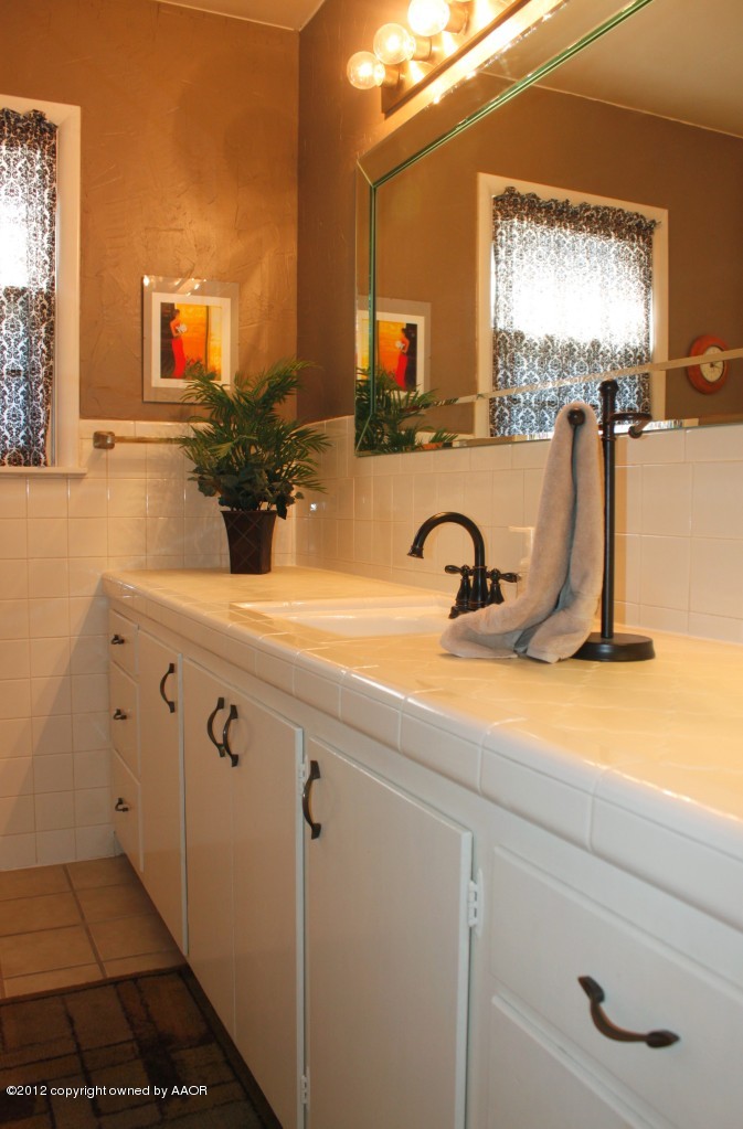 6104 Jameson Road Amarillo, TX 79106 - Photo 25 of 36 a bathroom with a sink and a mirror