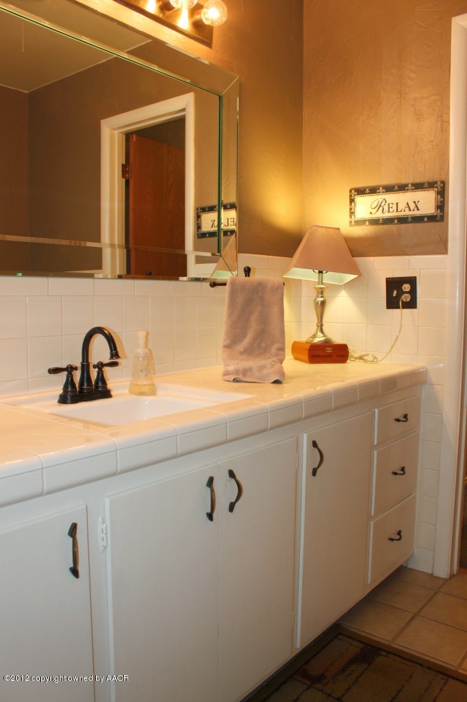6104 Jameson Road Amarillo, TX 79106 - Photo 26 of 36 a bathroom with a sink and a mirror