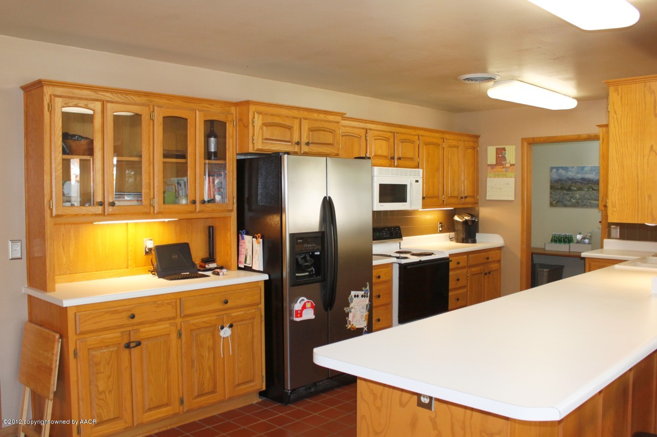 6104 Jameson Road Amarillo, TX 79106 - Photo 6 of 36 a kitchen with a refrigerator a sink dishwasher with a dining table and chairs
