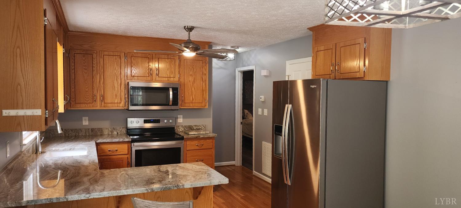 297 Poor House Farm Road Amherst, VA 24521 - Photo 12 of 52 a kitchen with stainless steel appliances granite countertop a refrigerator a stove top oven a sink and dishwasher