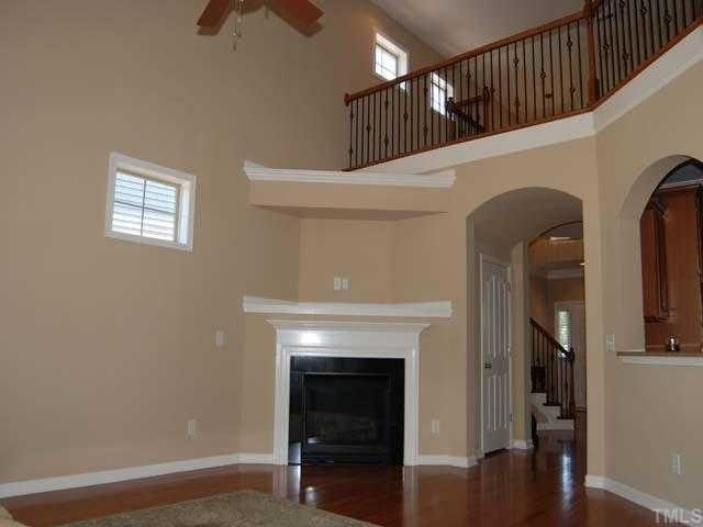 6227 Oconner Street Raleigh, NC 27617 - Photo 3 of 11 Hardwood floor, marble surround fireplace with gas logs, painted mantel, entertainment niche, arched doorways, upgraded ceiling fan with light, triple window with transoms and 2" blinds, 2 transom windows, smooth vaulted ceiling Living Room