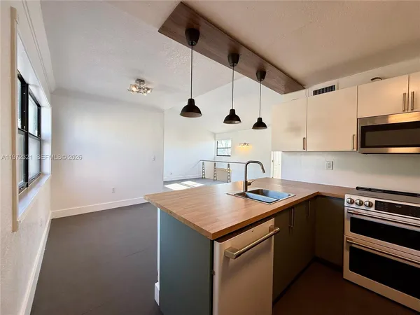a kitchen with stainless steel appliances granite countertop a sink and a stove
