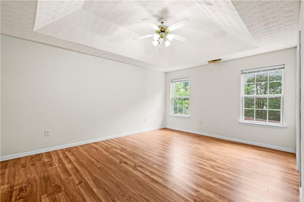 3740 Crescent Walk Lane Northeast Suwanee, GA 30024 - Photo 20 of 39 an empty room with wooden floor and windows