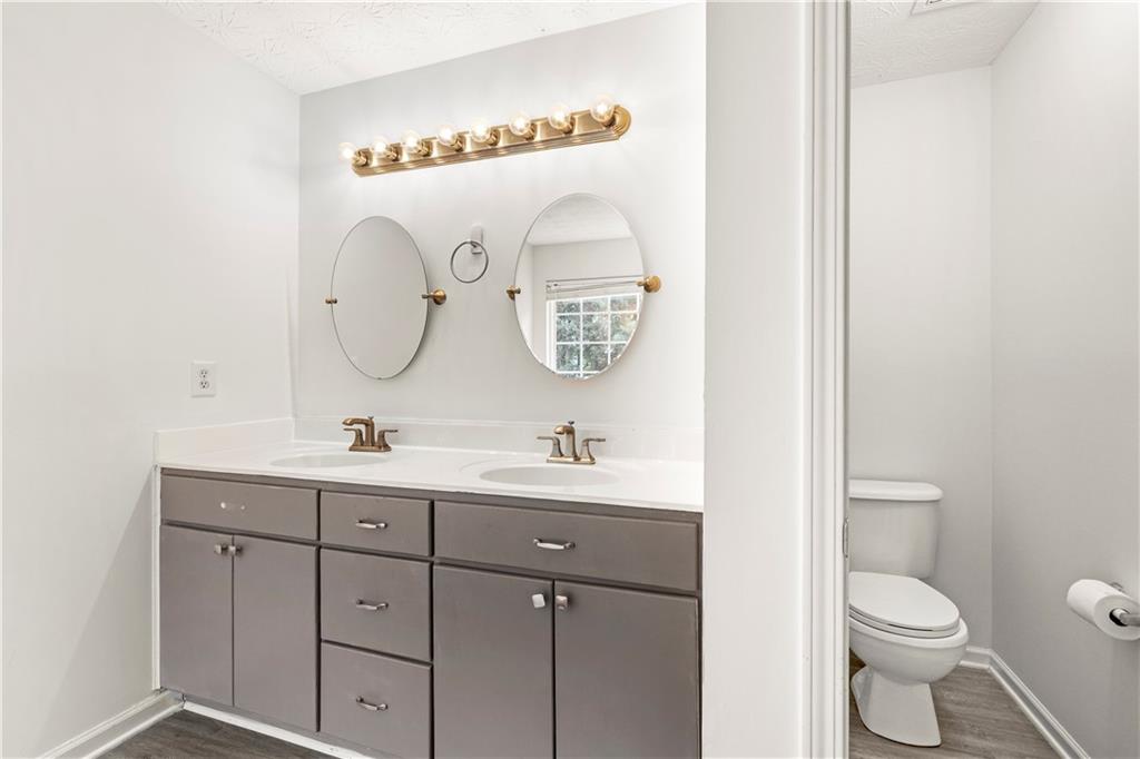 3740 Crescent Walk Lane Northeast Suwanee, GA 30024 - Photo 23 of 39 a bathroom with a toilet a sink and mirror