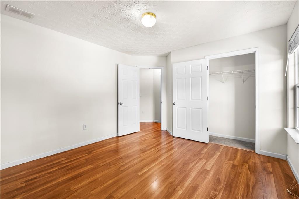 3740 Crescent Walk Lane Northeast Suwanee, GA 30024 - Photo 33 of 39 a view of an empty room with wooden floor and a window