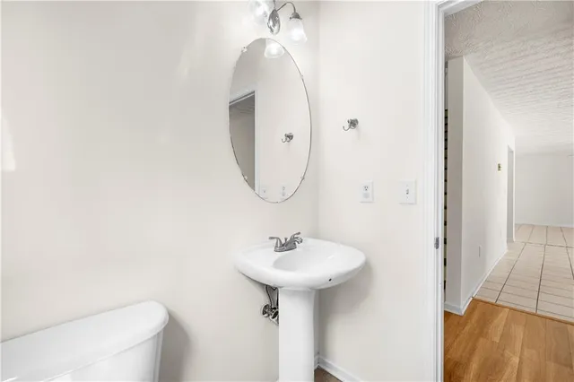 a bathroom with a sink a toilet and a mirror