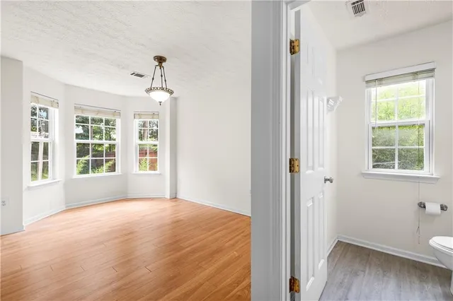 a view of a room with a window and wooden floor