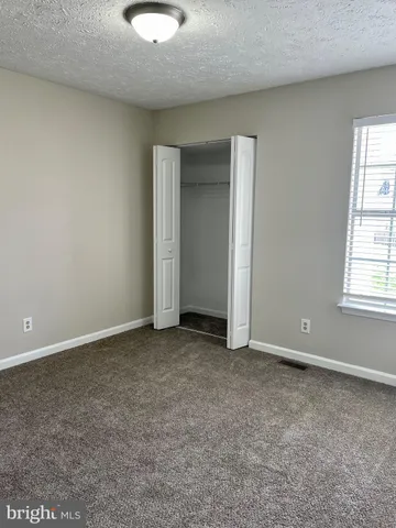 an empty room with windows and closet