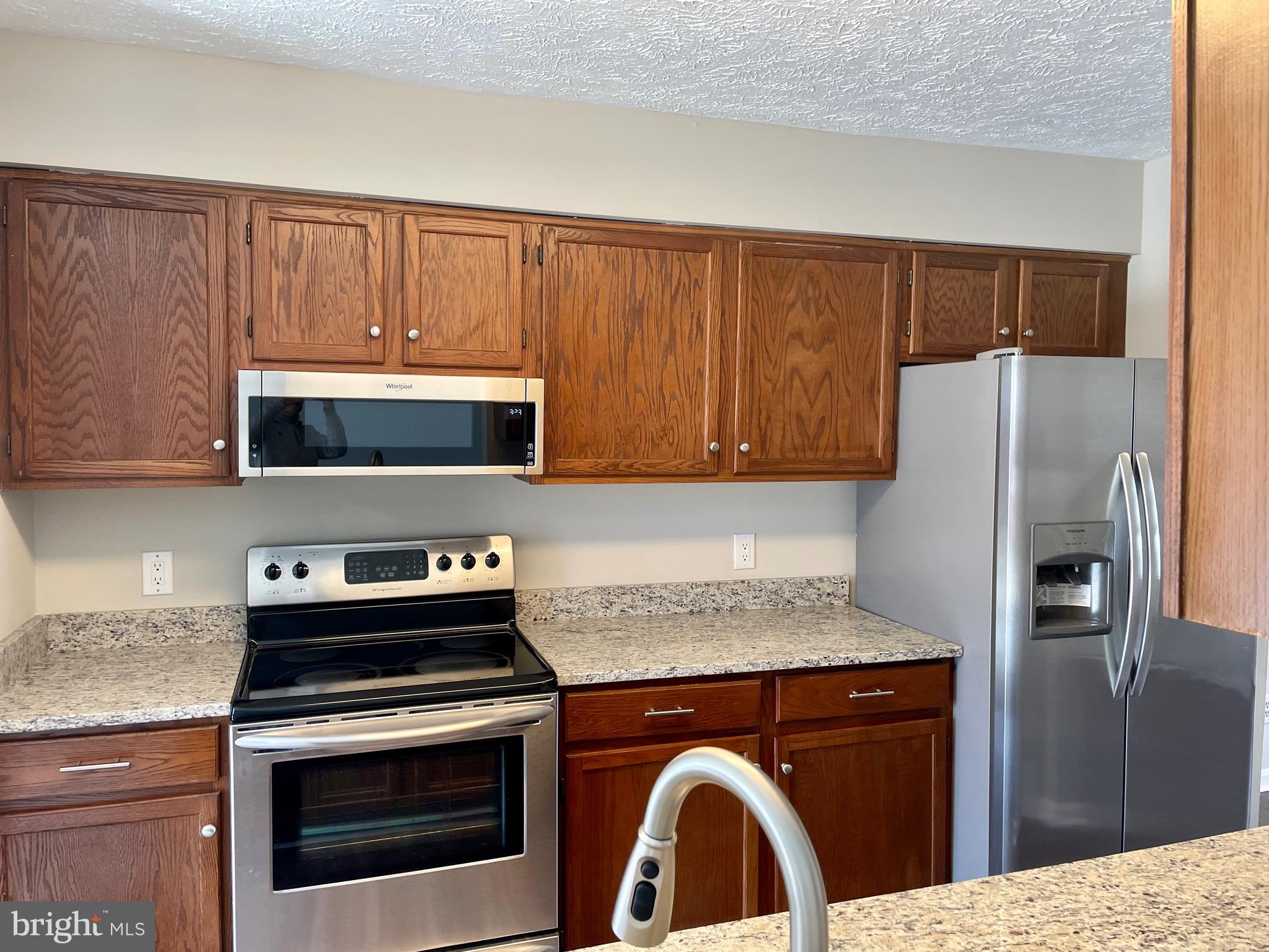 5126 Mallards Landing Drive King George, VA 22485 - Photo 2 of 19 a kitchen with stainless steel appliances granite countertop a stove a refrigerator and a microwave