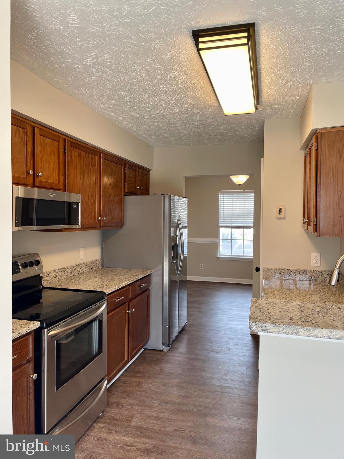 5126 Mallards Landing Drive King George, VA 22485 - Photo 6 of 19 a kitchen with stainless steel appliances granite countertop a stove a sink and a refrigerator