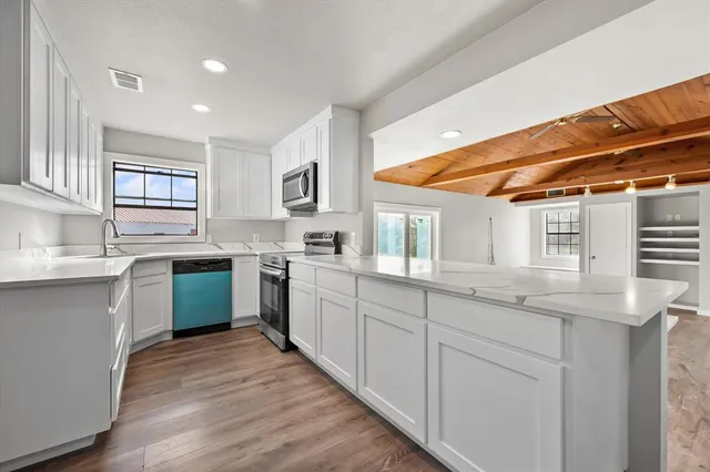 a kitchen with stainless steel appliances granite countertop a sink and cabinets