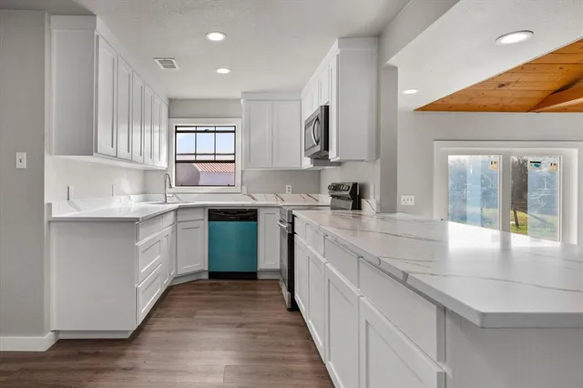 a kitchen with stainless steel appliances granite countertop a sink and cabinets